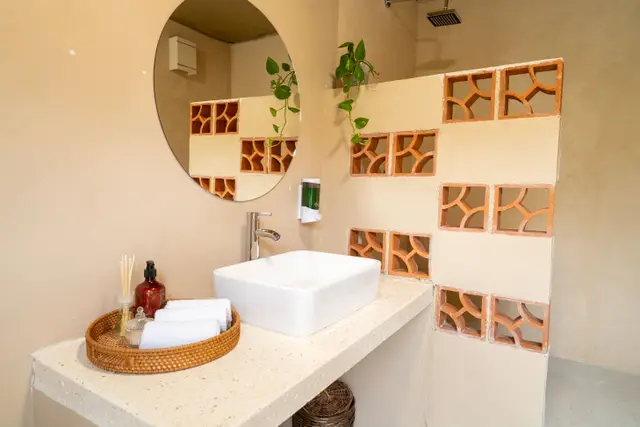 Baño con celosías de barro y amenidades