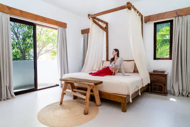 Suite con cama de dosel y vista al jardín